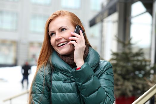 Happy young woman calling by phone