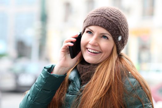 Happy young woman calling by phone