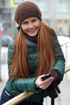 Happy young woman calling by phone