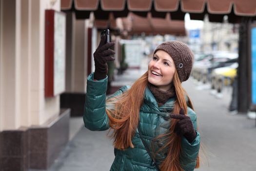 Happy young woman calling by phone