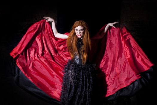 Terrible vampire woman in a red cloak