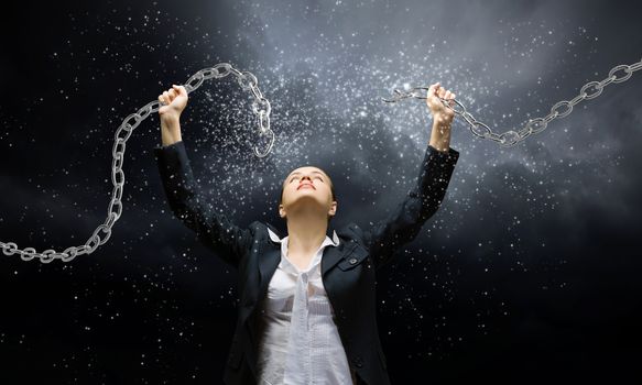 Image of businesswoman in anger breaking metal chain