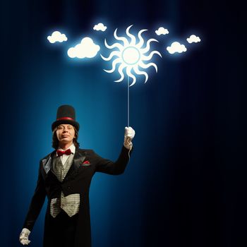 Image of man magician with balloon against color background