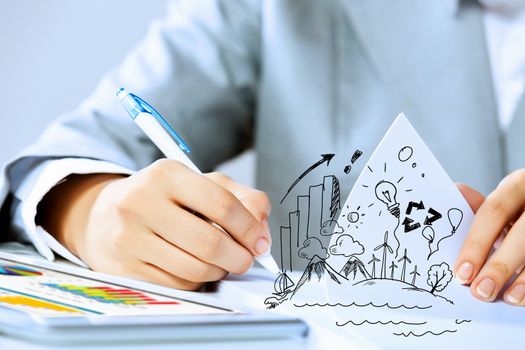 Image of businesswoman sitting at table and drawing sketch