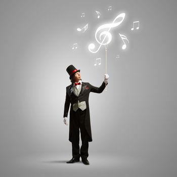 Image of man magician showing trick against color background