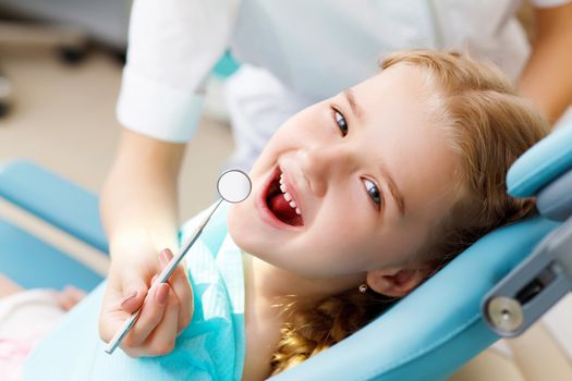 Little girl sitting in the dentists office