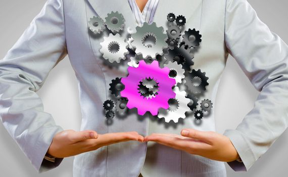 Close up image of businesswoman holding gears in hands