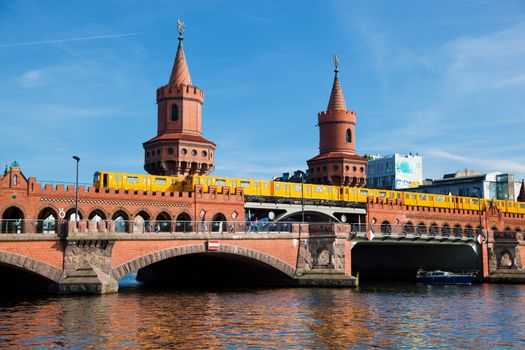 The Oberbaum Bridge, German Oberbaumbrucke and River Spree in Berlin, Germany. U-bahn going through the bridge