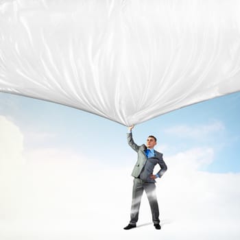 Image of young businessman pulling blank banner from above
