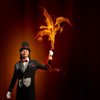 Image of man magician showing trick against color background