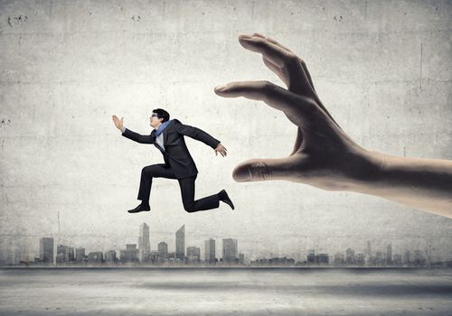 funny image of businessman trying to run away from hand