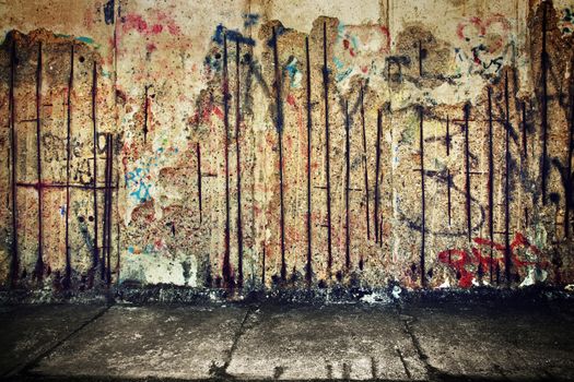 Grunge, rusty concrete wall with random graffiti and concrete floor. Grunge background