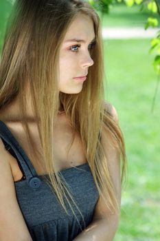 Portrait of the young beautiful woman on a background of leaves of a birch