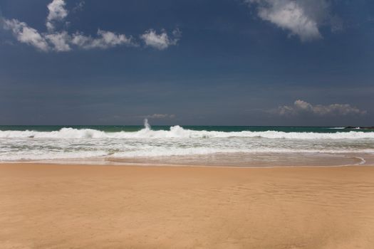 golden sand beach with blue ocean and cloudscape 