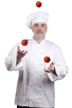 Cook in uniform juggles three tomatoes. Theme of healthy eating.