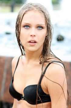 Young sexy woman bathes in a city fountain