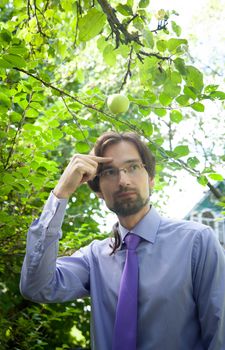 thinking man under the apple in the garden