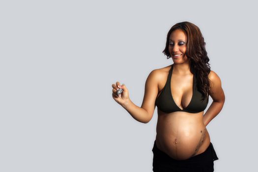 A lovely young multiracial woman, eight months pregnant, holds a heavy marker, allowing you to insert your own text or drawing as if she's writing or drawing it.