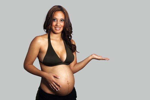 A lovely young pregnant woman with her hand out to her side, palm up, allowing you to put your graphic in her hand or have her pointing to your product.