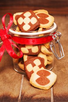 christmas cookies in a jar on wooden background in cozy light