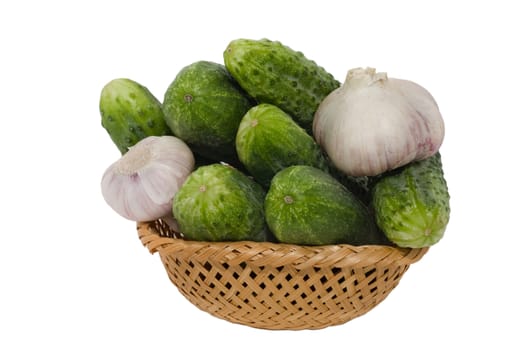 fresh cucumbers and garlic in   basket  isolated on white 