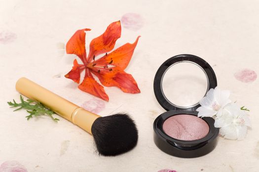 Makeup blusher rouge and brushes with orange lily