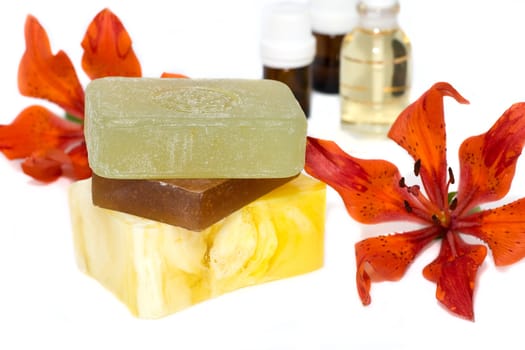 soap with natural ingredients , flowers an bottles of aromatic oil 