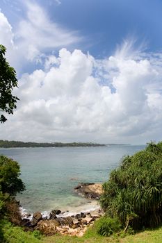 Tropical paradise with trees on beach, turquoise sea and boulders in the front  in Dikwella, Sri lanka