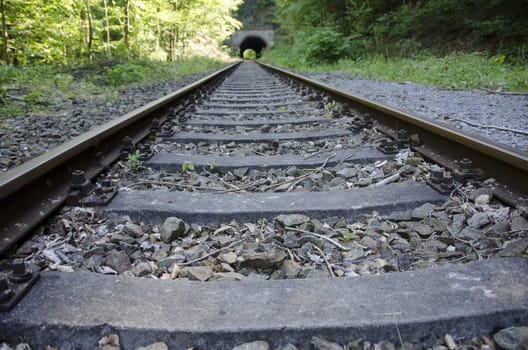 Old railway track with tunnel in the background