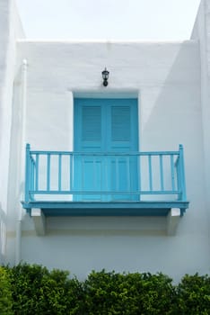 Vintage blue door and terrace on the white wall. 
