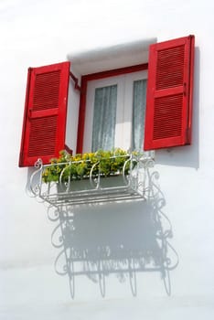 Vintage red window on the white wall and Basket of flowers.