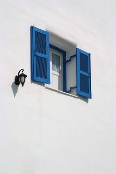 Vintage blue window on the white wall 