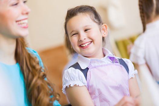 Little girl painting with teacher at kindergarten