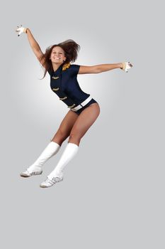 Young female dancer jumping against white background