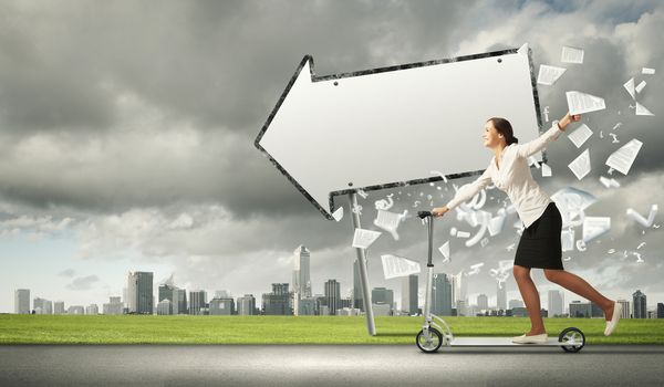 Image of attractive businesswoman riding a scooter