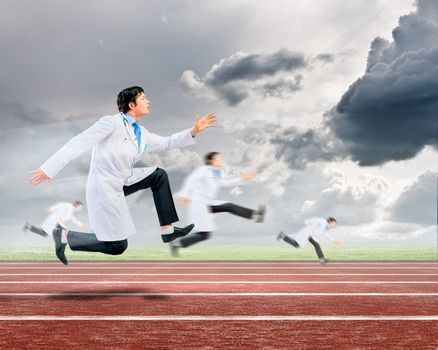 Funny image of young running doctor in white uniform