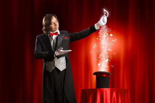 Image of magician holding hat with lights and fumes going out