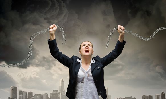 Image of businesswoman in anger breaking metal chain