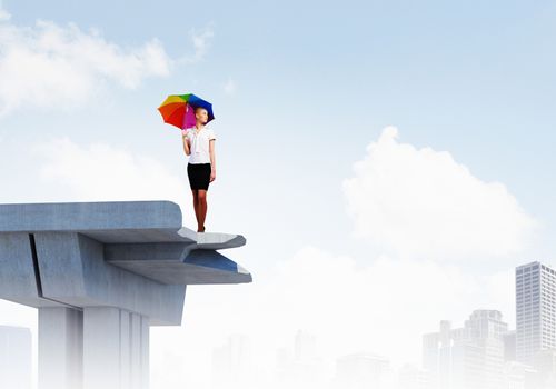 Image of businesswoman standing at the edge of bridge. Risk concept