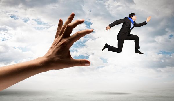 funny image of businessman trying to run away from hand