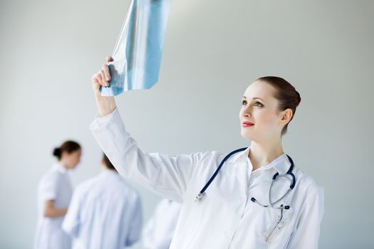 Attractive young female doctor examining x-ray results