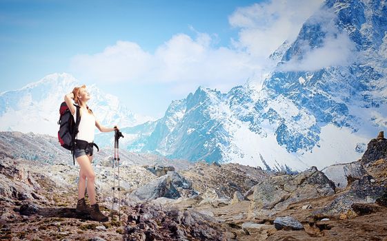 Pretty young woman tourist standing on top of mountain