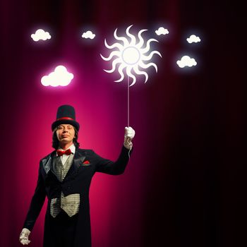 Image of man magician with balloon against color background