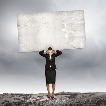 Image of businesswoman holding stone on her shoulders