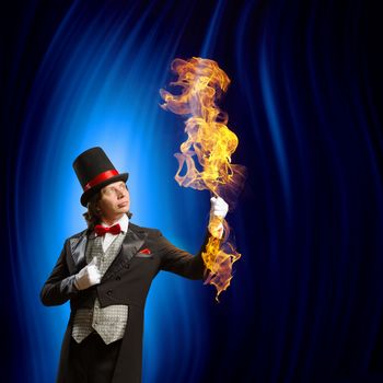 Image of man magician showing trick against color background