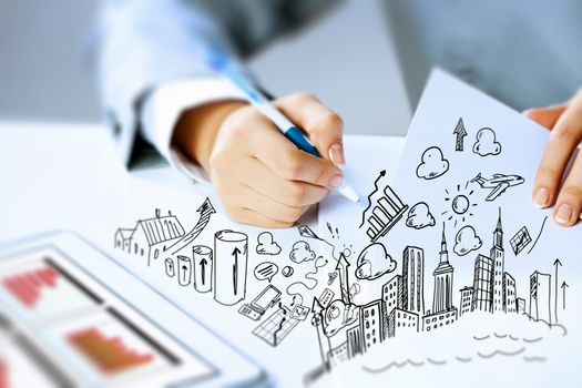 Image of businesswoman sitting at table and drawing sketch