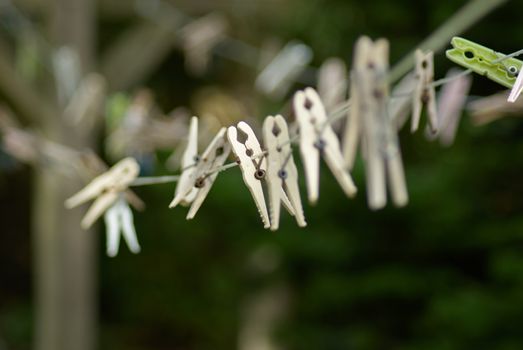 Plastic laundry clothespins clamps on rope shallow depth of field view