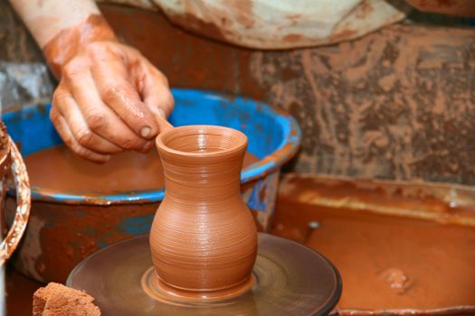 Potter shaping a ceramic  jar on a pottery wheel