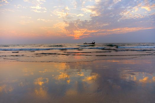 GOA, INDIA - 23 NOV 2011:  indian boat  at sunset in the seaon Arambol beach in Goa