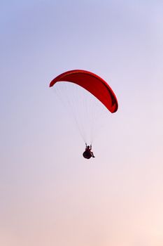 Paraglider final approach before landing in the evening sky